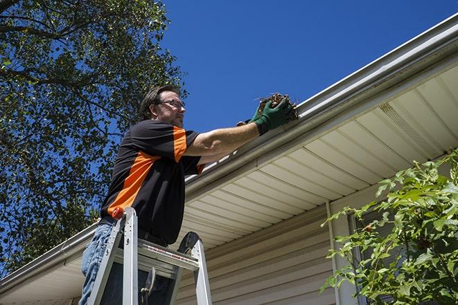 close-up of a technician fixing a gutter pipe in Charlotte, MI